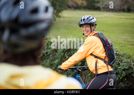 Female biker smiling while cycling Stock Photo