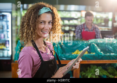 Female staff using digital tablet in organic section Stock Photo