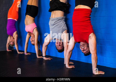 Athletes doing handstand in fitness studio Stock Photo