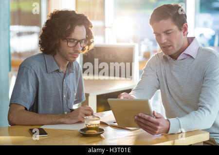 Male friends discussing on digital tablet Stock Photo