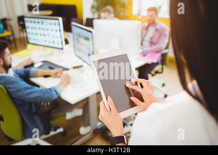 Rear view of executive using digital tablet at creative office Stock Photo