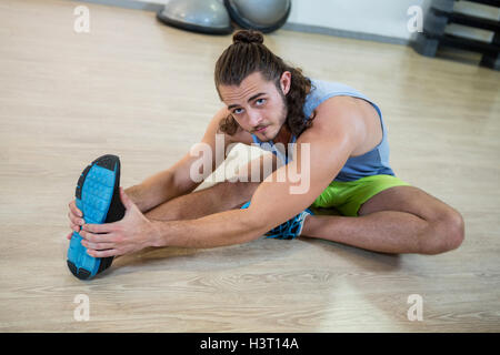 Portrait of man doing stretching exercise Stock Photo