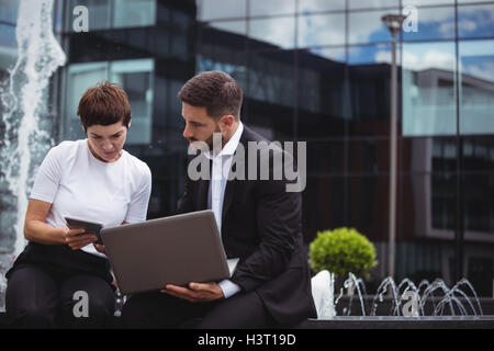 Businesspeople discussing on digital tablet and laptop Stock Photo