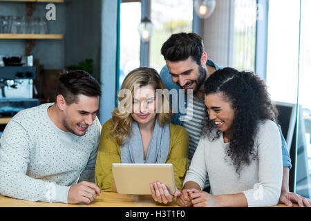 Friends using digital tablet in caf├⌐ Stock Photo