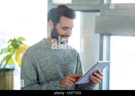 Man standing in caf├⌐ and using digital tablet Stock Photo