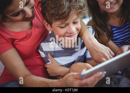 Mother and kids using digital tablet together Stock Photo