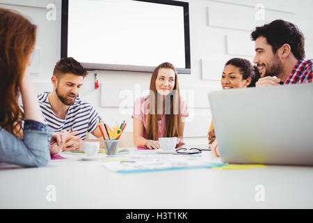 Happy coworkers discussing in meeting at creative office Stock Photo