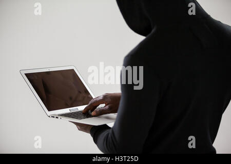 Hacker using a laptop Stock Photo