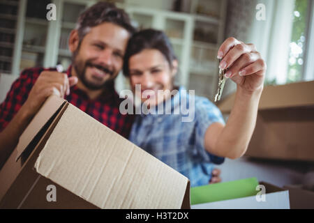 Smiling couple holding keys in their new house Stock Photo