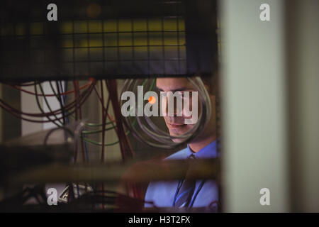 Technician checking cables in a rack mounted server Stock Photo