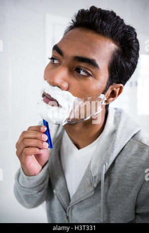 Man shaving in the bathroom Stock Photo