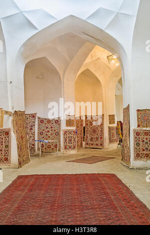 The rug store with the wide range traditional carpets and embroidered tablecloths in Bukhara. Stock Photo