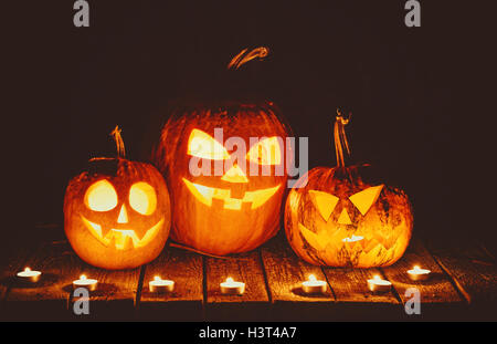 Halloween pumpkins head jack lantern with candles around on the old boards in a spooky night landscape. Soft focus. shallow DOF Stock Photo