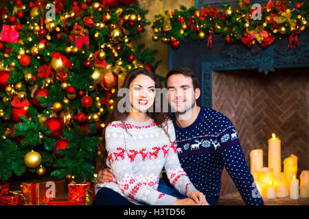 Young couple near fireplace celebrating Christmas. Love and relationship concept. Stock Photo