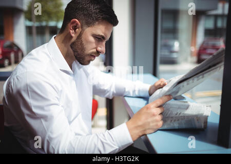 Businessman reading newspaper in office Stock Photo