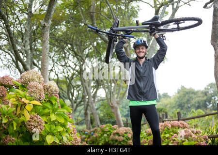 Male cyclist carrying mountain bike Stock Photo