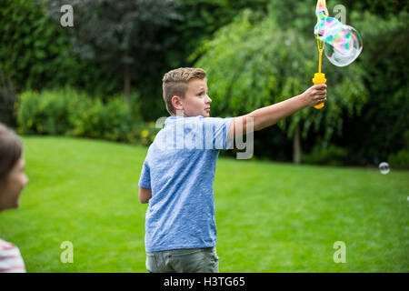 Kids playing with bubbles in the park Stock Photo