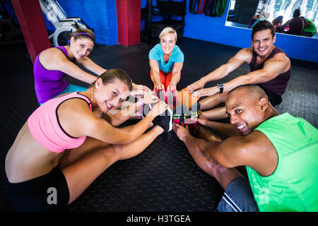 Portrait of smiling of friends stretching in gym Stock Photo
