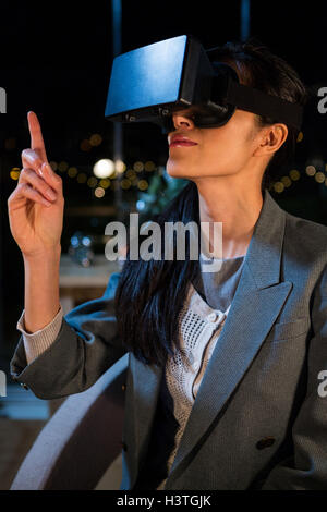 Businesswoman using virtual reality headset Stock Photo
