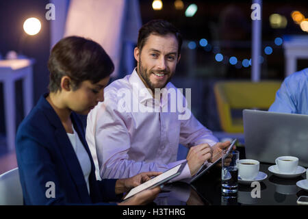 Businessman and businesswoman using digital tablet in office Stock Photo