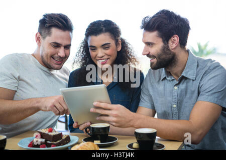 Three friends using a digital tablet Stock Photo