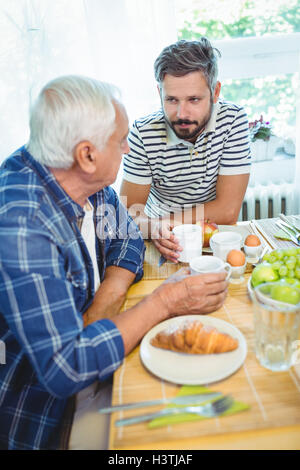Father and son talking to each other while having breakfast Stock Photo