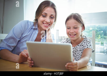 Smiling mother and daughter using digital tablet Stock Photo