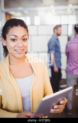 Portrait of happy businesswoman using digital tablet at creative office Stock Photo