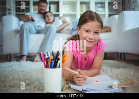 Girl lying on floor drawing picture Stock Photo - Alamy