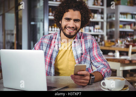 Portrait of happy man holding mobile phone Stock Photo