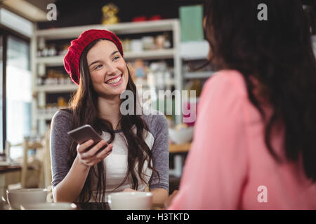 Woman using mobile phone in cafe Stock Photo