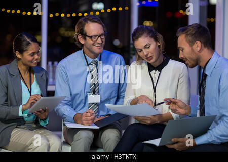 Businesswoman discussing with colleagues over document Stock Photo