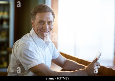 Smiling man using a digital tablet in caf├⌐ Stock Photo