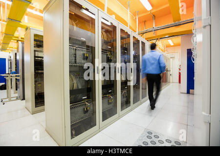 Technician walking in server room Stock Photo