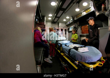 Two EMTs siting inside an ambulance talking to children, Fire Prevention Week Stock Photo