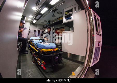 Two EMTs siting inside an ambulance Stock Photo