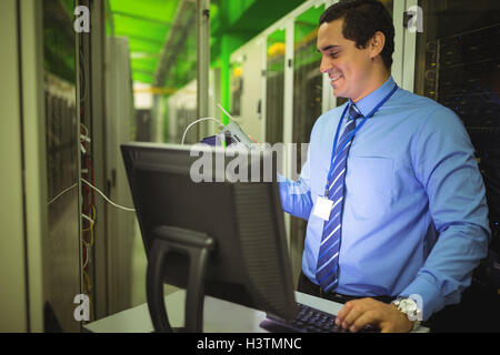 Technician using digital cable analyzer while working on personal computer Stock Photo