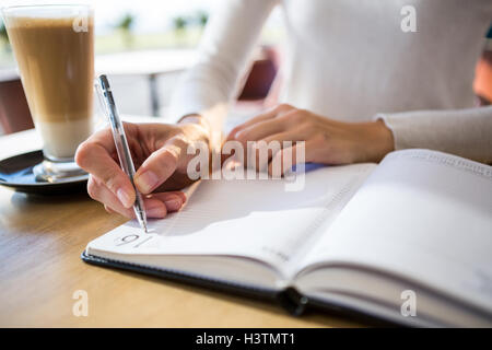 Woman writing in diary Stock Photo