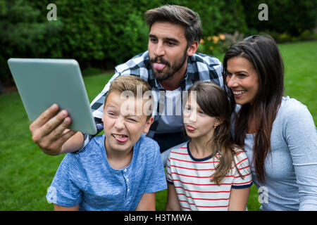 Happy family taking a selfie from digital tablet in park Stock Photo