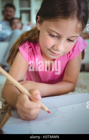 Girl coloring while lying on floor at home Stock Photo - Alamy