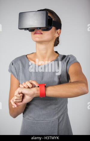 Woman touching smart watch and using virtual reality headset Stock Photo