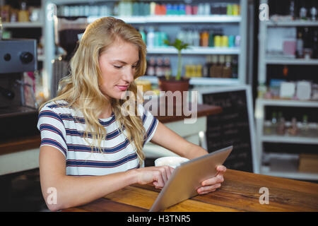 Woman sitting in a cafe using digital tablet Stock Photo