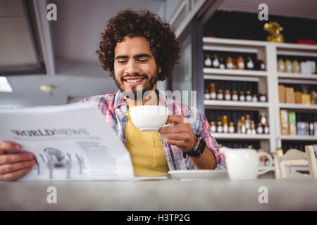 Man reading newspaper while having coffee Stock Photo