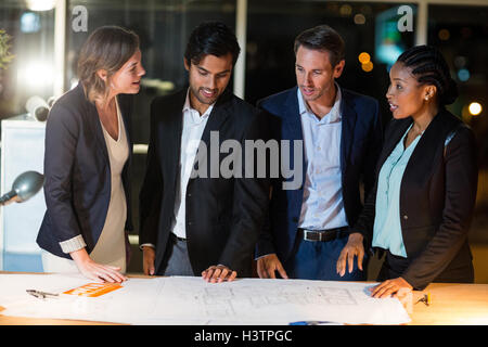 Group of businesspeople discussing over blueprint Stock Photo