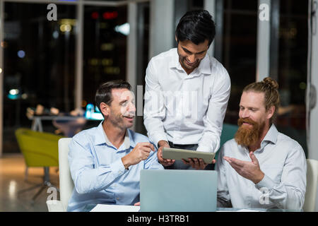 Businessmen discussing over digital tablet Stock Photo