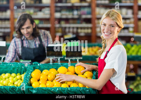 Smiling female staffs checking fruits in organic section Stock Photo