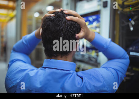 Stressed technician working on server maintenance Stock Photo