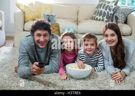 Family watching television while lying on the floor