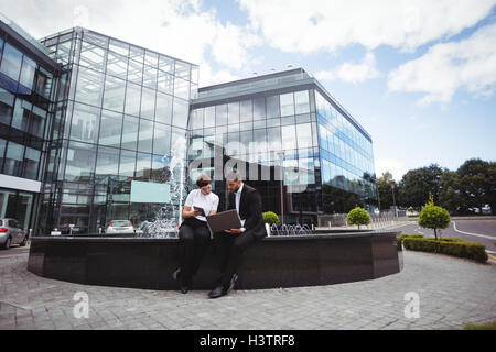 Businesspeople discussing on digital tablet and laptop Stock Photo