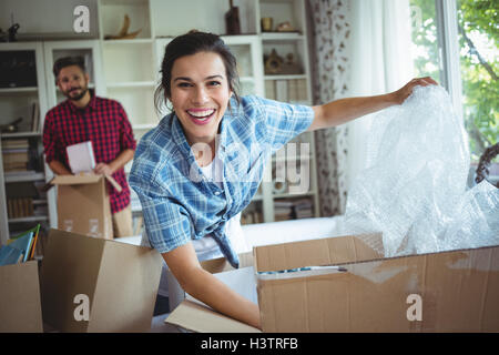 Happy couple unpacking cartons together Stock Photo